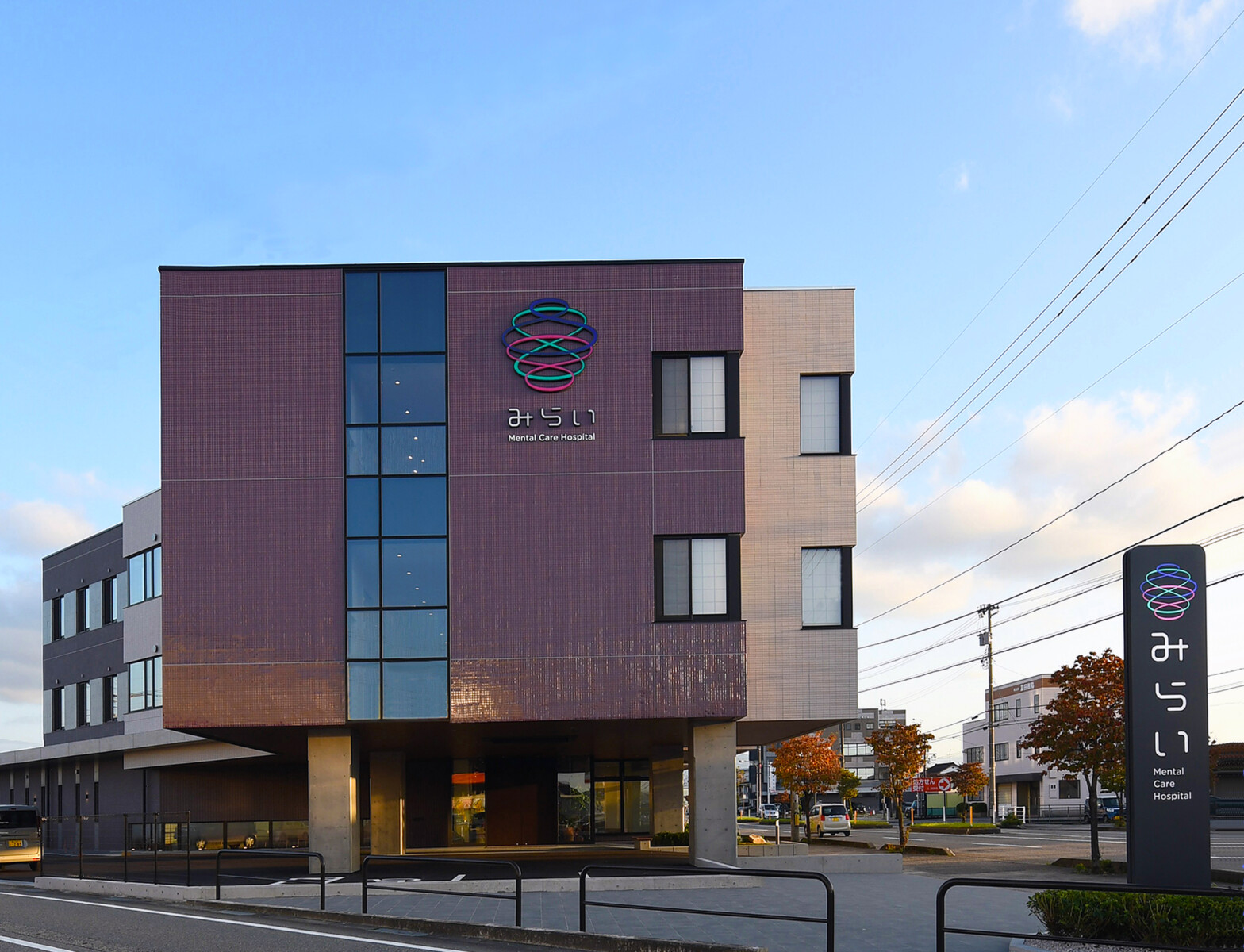 夕景にサインが映えるエントランスまわり外観