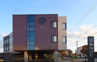 夕景にサインが映えるエントランスまわり外観